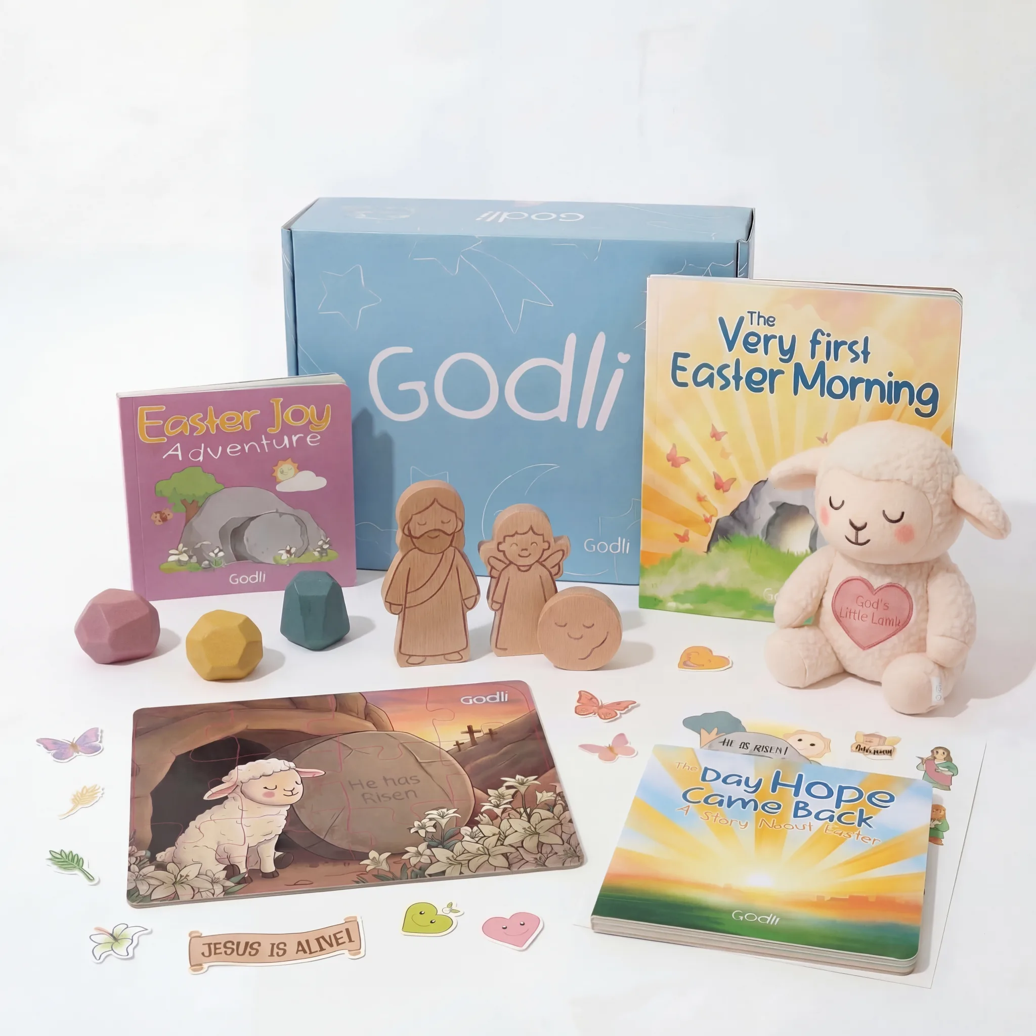 Easter Godli Box — faith-based Montessori toys, Easter board books, plush lamb, activity sheets and sticker set laid out on a warm cream surface